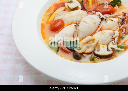 Kalmare und Zitronengras würzige Suppe mit Pilzen, Tomaten und Kräutern Stockfoto