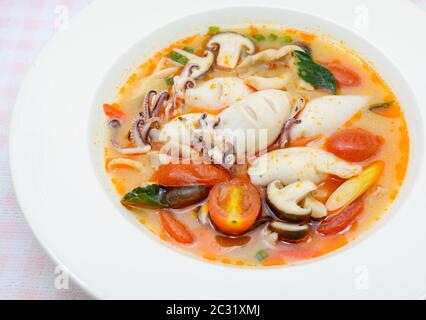 Kalmare und Zitronengras würzige Suppe mit Pilzen, Tomaten und Kräutern Stockfoto