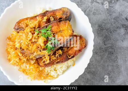 Frittierte scheiben Pangasius Fisch mit Knoblauch, mit braunem Reis serviert. Stockfoto