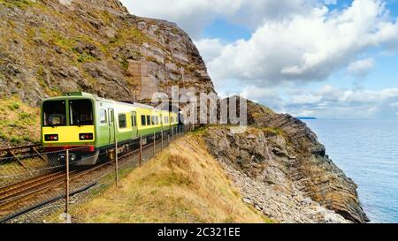 Nahaufnahme des Zuges, der aus einem Tunnel fährt. Blick vom Cliff Walk Bray nach Greystones, Irland Stockfoto