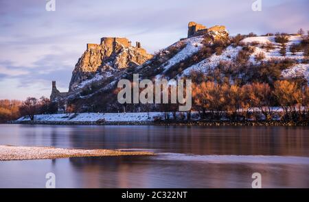 Schneebedeckte Ruinen der Burg Devin über der Donau in Bratislava, Slowakei bei Sonnenaufgang Stockfoto