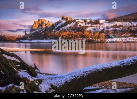 Schneebedeckte Ruinen der Burg Devin über der Donau in Bratislava, Slowakei bei Sonnenaufgang Stockfoto