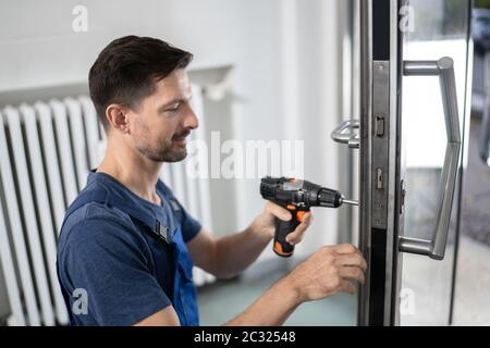 Portrait Junge männliche Tischler reparieren Türschloss Stockfoto