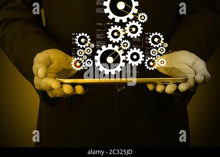 Digitale Tablet in der Hand und Zahnräder Stockfoto