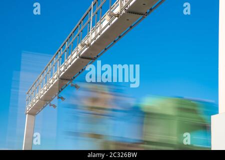 LKW fährt durch die Autobahn durch die Mautstelle, Mautgebühren, verschwommene Bewegung im Bild. Stockfoto