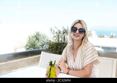 Hübsche Frau mit einem Glas Passionsfrucht-Cocktail Stockfoto
