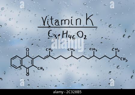 Strukturelle Modell von Vitamin K auf dem Glas mit Regentropfen. Stockfoto