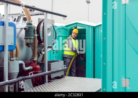 Arbeiter Pumpen Fäkalien aus Miettoilette zur Entsorgung und Reinigung Stockfoto