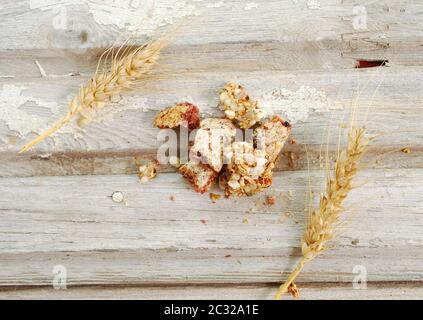 Stücke von einem süßen Cornflakes und Müsli Ohren auf einem alten Holz Stockfoto