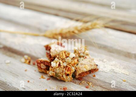 Stücke von einem süßen Cornflakes und Müsli Ohren auf einem alten Holz Stockfoto