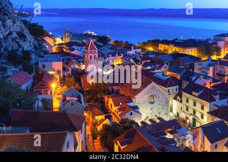 Roten Dächer der Altstadt und die Kirche des Hl. Michaelat Nacht, Omis, beliebter Touristenort in Kroatien Stockfoto