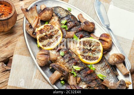 Ganze pelengas Fisch mit Pilzen und Zitrone gebacken. Sea Food. gegrillter Fisch mit Pilzen. Stockfoto