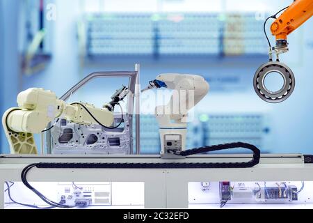 Industrielle Robotik Arbeiten an der Automatisierung mit Autoteilen in Smart Factory auf Blauton Farbe verschwommen Hintergrund Stockfoto