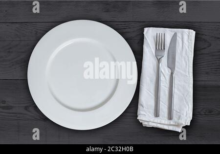 Leerer Teller mit Besteck auf anthrazit Holz. Stockfoto