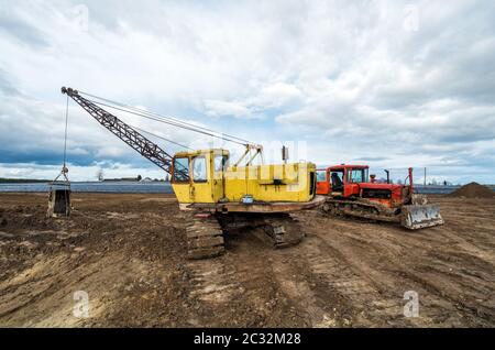 Die Bagger und alten roten Traktor im Feld Stockfoto