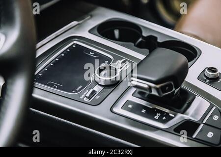 Touch-Panel in einem Premium-Fahrzeug. Verwaltung von Multimedia-Funktionen und Optionen des Autos, Navigation, Musik. Getränkehalter und Schalthebel. Stockfoto
