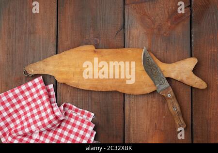 Holz Schneidebrett in Form eines Fisches und ein scharfes Messer, braun Tabelle von Brettern, Ansicht von oben Stockfoto