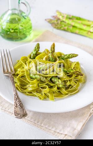 Portion Spinat Bandnudeln mit gebratenem Spargel Stockfoto