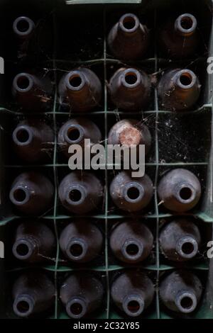 Blick auf einen Haufen verlassener Bier- und Sodaflaschen in einer Scheune. Stockfoto