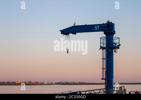 Blick auf einen Blauen Kran auf den Docks zum Anheben von Booten in Vila Real Santo Antonio, Portugal. Stockfoto