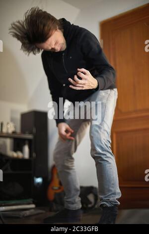 Luftgitarre spielen Musik in einem Raum hören, konzentrieren sich auf die Hand, Kopfknallen Kopf verschwommen Stockfoto