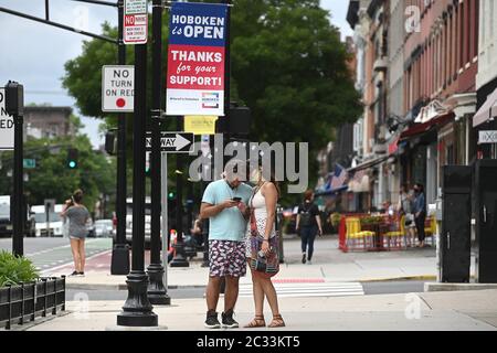 Hoboken, USA. Juni 2020. Ein Paar steht nahe beieinander, als sie sich auf dem Weg entlang der Washington Street in Hoboken, NJ, 18. Juni 2020, machen. Nach Monaten der Stilllegung von COVID-19, um die Ausbreitung des tödlichen Virus zu verhindern, erlauben neue Stadtverordnungen Unternehmen, Gehwegsflächen zu nutzen, um die Gastronomie-Shopping-Öffentlichkeit zu bedienen.(Anthony Behar/Sipa USA) Kredit: SIPA USA/Alamy Live News Stockfoto