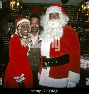 Sänger Barry White kleidete sich als Weihnachtsmann mit Frau Glodean und Boxchamps Sugar Ray Robinson bei einem Chirstmas-Event für Robinson's Wohltätigkeitsorganisation um die 1980er Jahre in Bevelrey Hills, CA Stockfoto