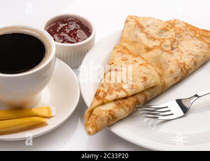 Frisches Dessertpfannkuchen und kräftiger Kaffee auf Weiß Stockfoto