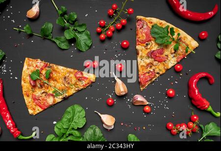 Dreieckige Stück Pizza mit Pilzen, geräucherte Wurst, Tomaten und Käse, schwarzer Hintergrund, flach Stockfoto