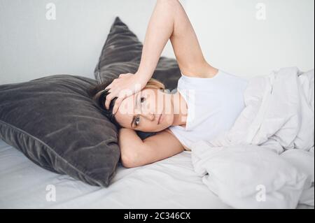 Depressive Frau gequält durch unruhigen Schlaf, sie ist erschöpft und leidet an Schlaflosigkeit, schlechten Träumen oder Alpträumen, psychischen Problemen Stockfoto