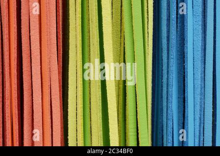 Ausschnitt Textur closeup auf mehrere orange, grün und blau bunt Lederbändern. Stockfoto