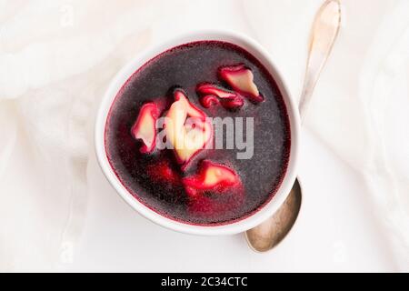 Weihnachtssuppe mit Rote Bete, Borscht mit kleinen Knödeln mit Pilzfüllung Stockfoto