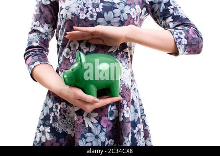 Nahaufnahme einer unerkennbaren jungen Frau, die ein grünes Sparschwein in den Händen hält, isoliert auf weißem Hintergrund. Konzept speichern. Denken an die Zukunft Stockfoto