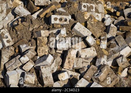 Nach der Zerstörung des alten Gebäudes stapelten sich Ziegel und andere gebrochene Baumaterialien, Nahaufnahme der Baustelle Stockfoto