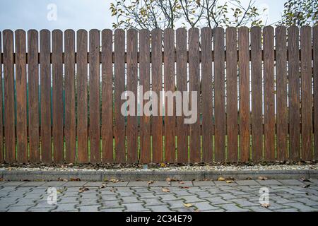Neue Holz- braunen Zaun vor der grünen Garten der Familie Haus Stockfoto