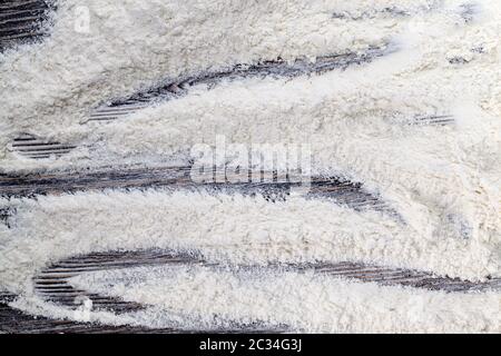 Ein kleiner Haufen gegossenes Weizenmehl auf einem alten Holzbrett Garprodukte Stockfoto