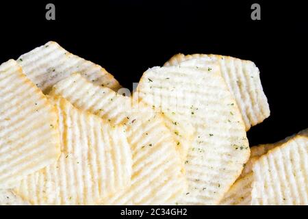 Chips aus echten Kartoffeln in Gewürzen und Aromen zur Verbesserung des Geschmacks, gewöhnliche Kartoffelchips mit einer gewellten Oberfläche, aus nächster Nähe Stockfoto