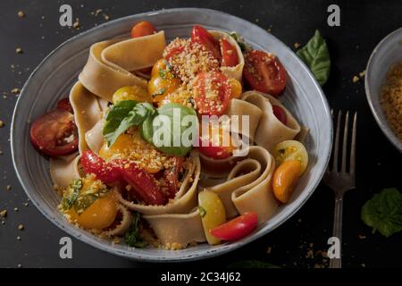 Gesundes Vollkornbrot Pappardelle mit frischen Tomaten und Basilikum, und einer veganen Mutter basiert. Stockfoto