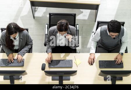 Blick von oben auf die jungen Erwachsenen freundlich und Vertrauen Betreiber Team Agent mit Headsets, die in einem Call Center, Kundendienst und technische Unterstützung. Stockfoto