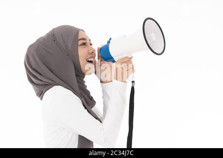 Junge Erwachsene muslimisch-arabischen Frau, tragen, Hijab kommuniziert schreien laut Holding ein Megaphon für Idee für Marketing oder Vertrieb. Studio shot isoliert Stockfoto