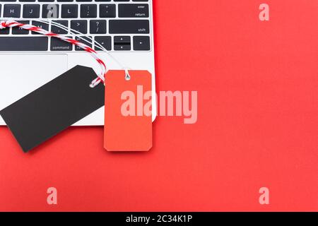 Leer rot Tag label und schwarzen Tag label Shopping Konzept auf Laptop, mit Kopie Raum auf rotem Hintergrund Stockfoto