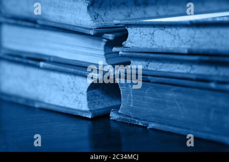 Close up Stack von sechs alten Vintage classic Leder gebundene Bücher auf dem Tisch, blau getönt, Low Angle View Stockfoto