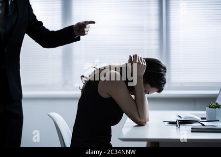 Nahaufnahme der Unternehmer Streiten für junge geschäftsfrau am Schreibtisch Stockfoto