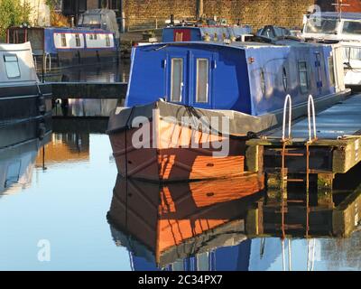 Alte schmale Boote, die in Hausboote umgewandelt wurden, vertäuten in der Marina am brighouse Basin in West yorkshire Stockfoto