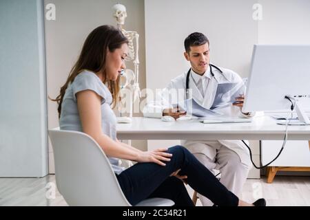 Arzt in Diskussion mit Patienten über Knie X-ray Stockfoto