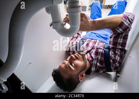 Klempner, Mit Dem Ein Sink Im Bad Befestigt wird Stockfoto
