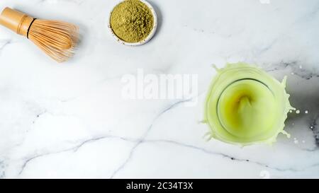 Hausgemachte Eistee Matcha Latte mit Spritzern auf weißem Hintergrund. Top View oder flach. Kopieren Sie Platz für Text oder Design Stockfoto