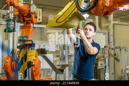 Vor dem Start des Prozesses eine Roboterlinie mit automatischen Armen einrichten. Stockfoto