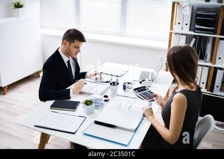 In der Nähe von zwei Geschäftsleute, die Berechnung des finanziellen Erklärung am Schreibtisch Stockfoto