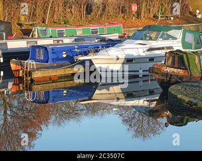 Alte schmale Boote, die in Hausboote umgewandelt wurden, vertäuten in der Marina am brighouse Basin in West yorkshire Stockfoto